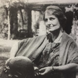 A black and white photo of a person posing for a photo in a shawl