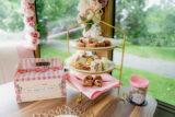 a mini tower of desserts sits on a table with a to-go mug and box