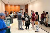 A group of people mingle in the lobby of a lecture hall.