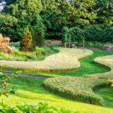 A flowing design of tall grasses sits in a field in this green garden space