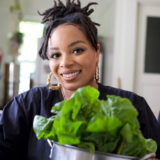 A person holding a potted green plant poses for a photo