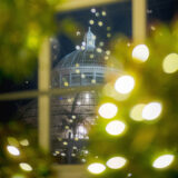 A twinkling white conservatory dome viewed through a clear window