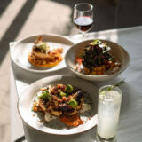 A trio of plates set with seasonal fall meals, sitting on a sunny dining table