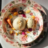 An elegantly plated dessert featuring orange and red fruits