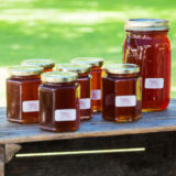 A collection of honey jars sitting on a wooden box