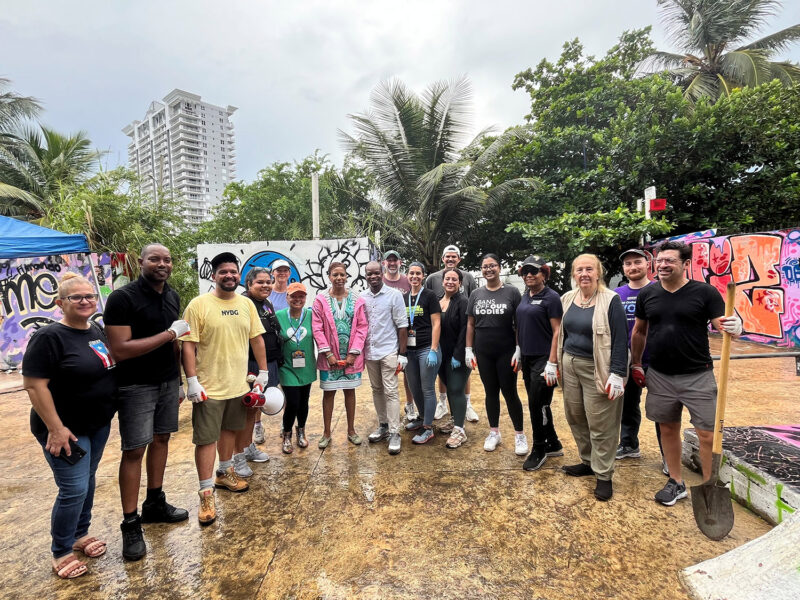 A group of people pose for a photo in a tropical outdoor location