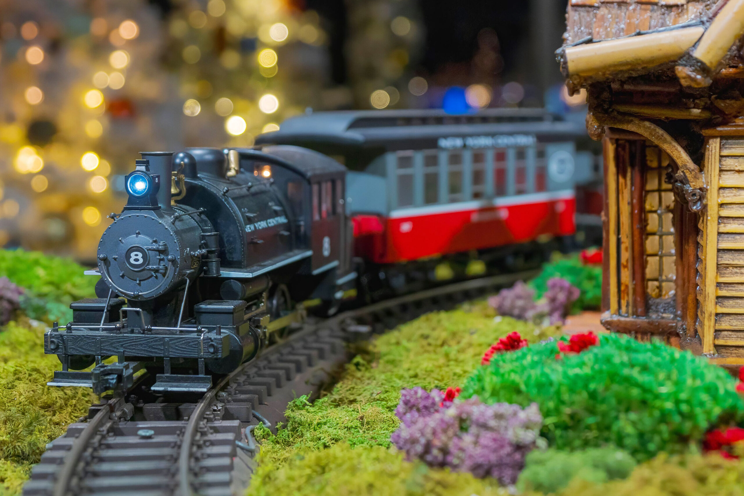 A black model train travels along a toy track