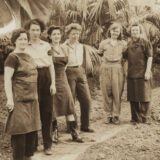 A group of six people pose for a black and white photo outdoors