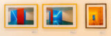 An arrangement of three framed photographs on a gallery wall