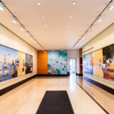 A brightly lit gallery space with colorful images on the walls